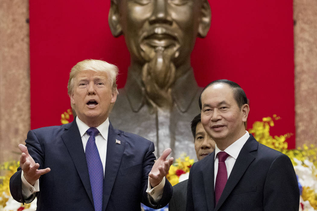 A large statue of Ho Chi Mihn is visible behind President Donald Trump and Vietnamese President Tran Dai Quang as they pose for photographers at the Presidential Palace, Sunday, Nov. 12, 2017, in  ...