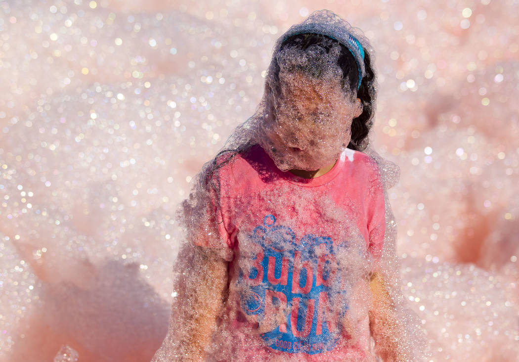 Ten-year-old Meleny Delgado is covered in foam during the Bubble Run 5K event at Sam Boyd Stadium in Las Vegas, Saturday, Nov. 18, 2017. Richard Brian Las Vegas Review-Journal @vegasphotograph