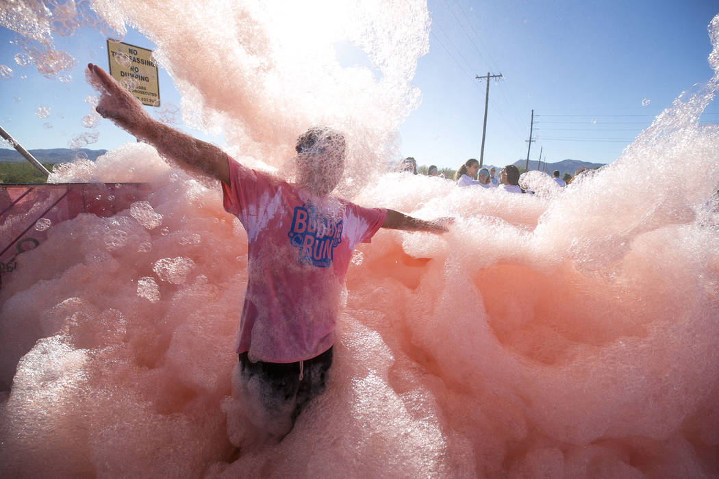Las Vegas resident Mark Egbalic, 12, runs through a foam sprayer during the Bubble Run 5K event at Sam Boyd Stadium in Las Vegas, Saturday, Nov. 18, 2017. Richard Brian Las Vegas Review-Journal @v ...