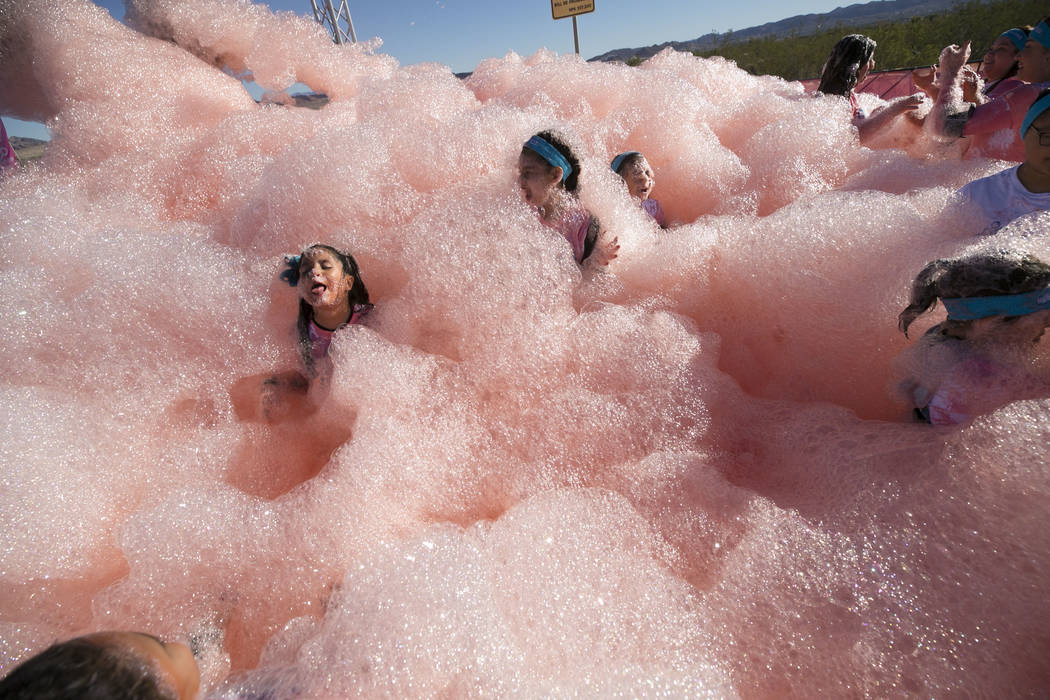 Children are engulfed by foam as they take part in the Bubble Run 5K event at Sam Boyd Stadium in Las Vegas, Saturday, Nov. 18, 2017. Richard Brian Las Vegas Review-Journal @vegasphotograph