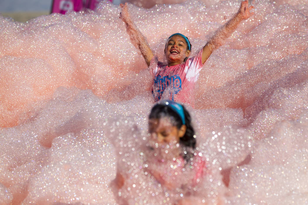 Eleven-year-old Leilany Delgado plays in foam during the Bubble Run 5K event at Sam Boyd Stadium in Las Vegas, Saturday, Nov. 18, 2017. Richard Brian Las Vegas Review-Journal @vegasphotograph