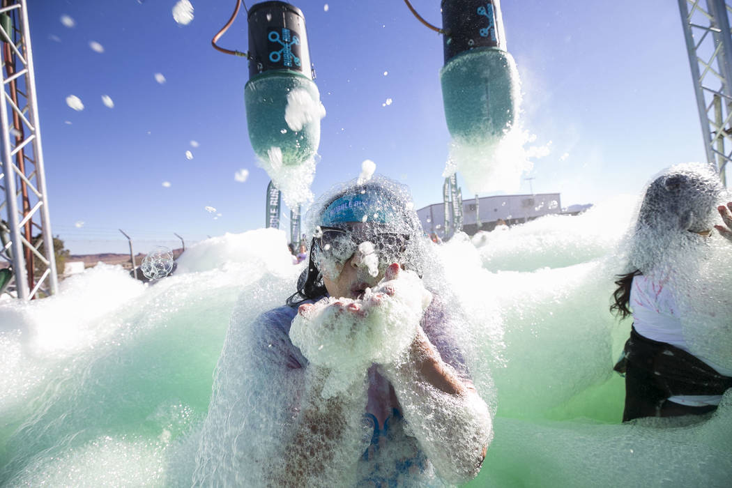 A participant blows foam at the camera during the Bubble Run 5K event at Sam Boyd Stadium in Las Vegas, Saturday, Nov. 18, 2017. Richard Brian Las Vegas Review-Journal @vegasphotograph
