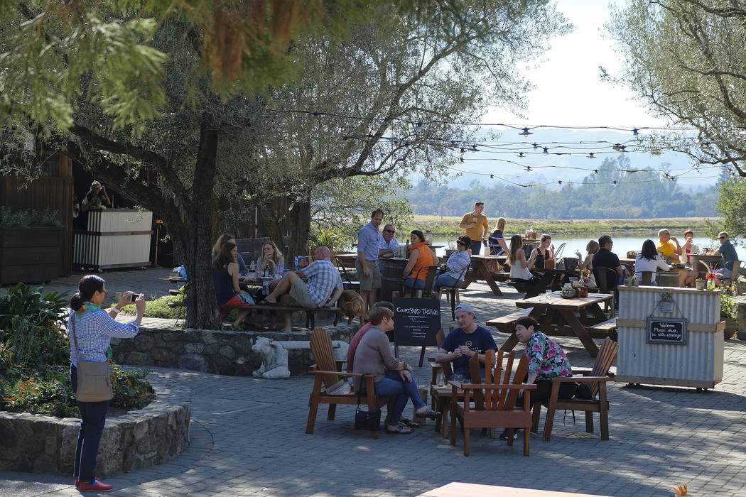 People fill a patio tasting wine and listening to music at the historic Gundlach Bundschu winery in Sonoma, Calif., last month. (AP Photo/Eric Risberg)