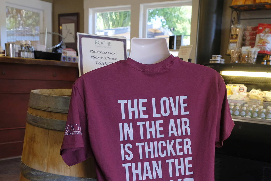 A T-shirt referencing the recent wildfires is shown for sale in the tasting room at Roche Winery and Vineyards in Sonoma, Calif., last month.  (AP Photo/Eric Risberg)