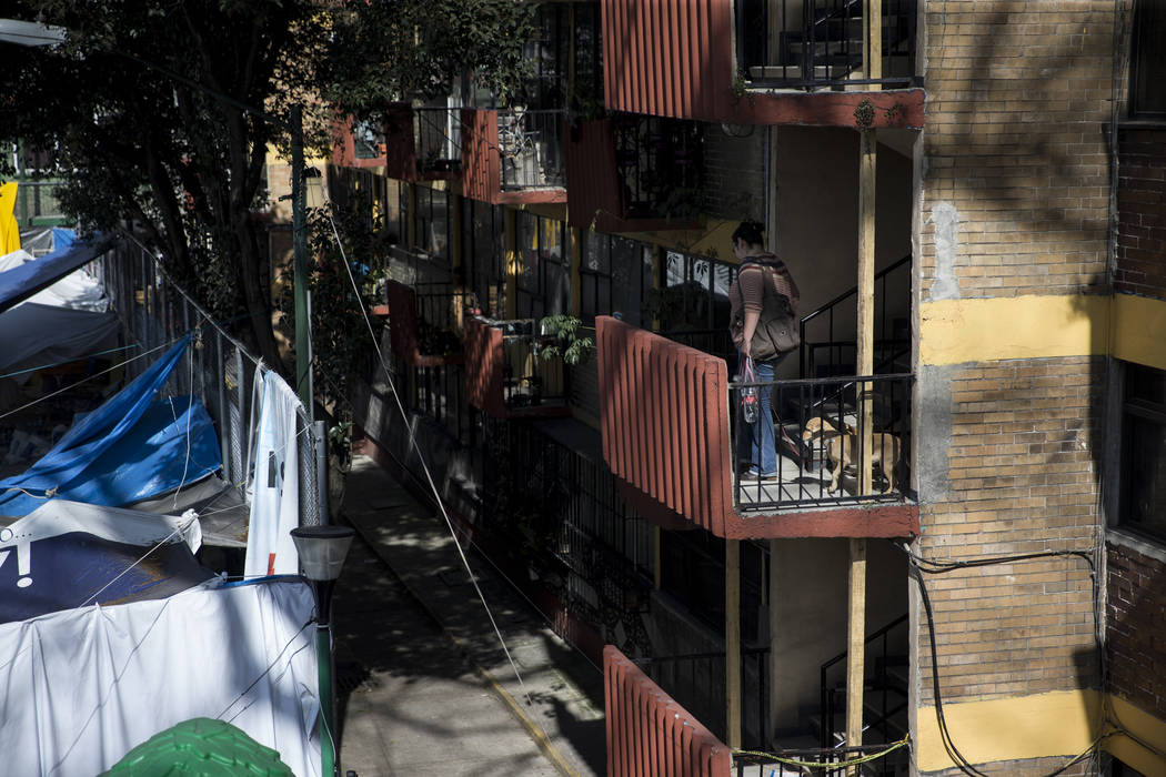A woman walks up the stairs of the Unidad Habitacional de Tlalpan apartments complex, which was deemed unhabitable after suffering structural damage during the Sept. 19 earthquake in Mexico City,  ...