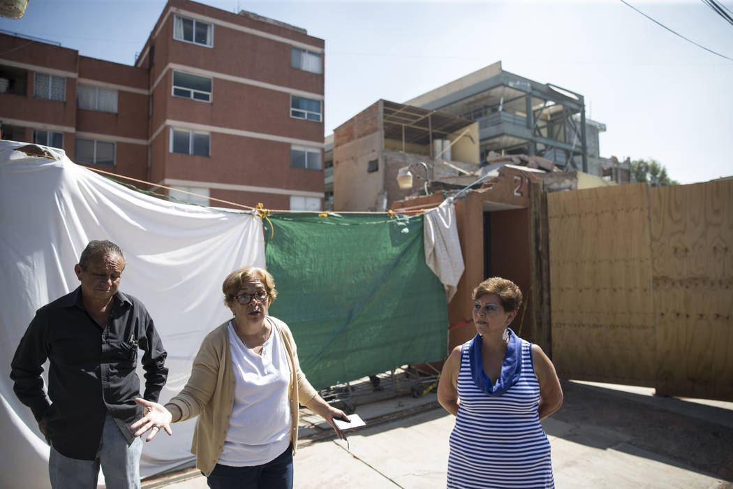 Gustavo Godinez Cadena, from left, his sister Georgina, and neighbor Elsa Garcia, outside of their homes and in front of Colegio Enrique Rebsamen elementary school, which collapsed during the Sept ...