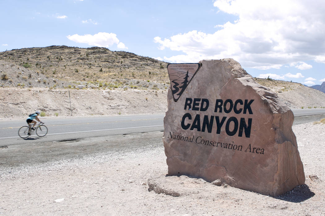A biker passes a sign for Red Rock Canyon National Conservation Area on Tuesday, Aug. 22, 2017, in Las Vegas. Bridget Bennett Las Vegas Review-Journal @bridgetkbennett