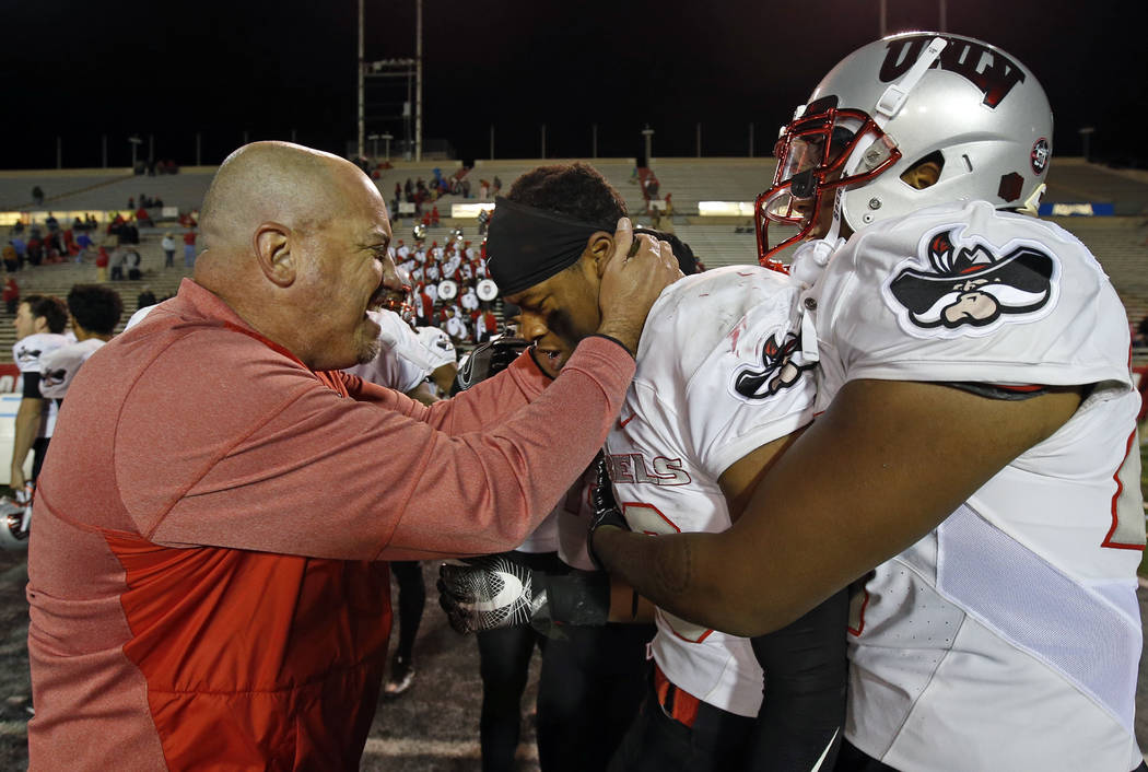 UNLV coach Tony Sanchez, left, congratulates linebacker Javin White (16) after White broke up a pass intended for New Mexico wide receiver Q' Drennan in the final minute of an NCAA college footbal ...