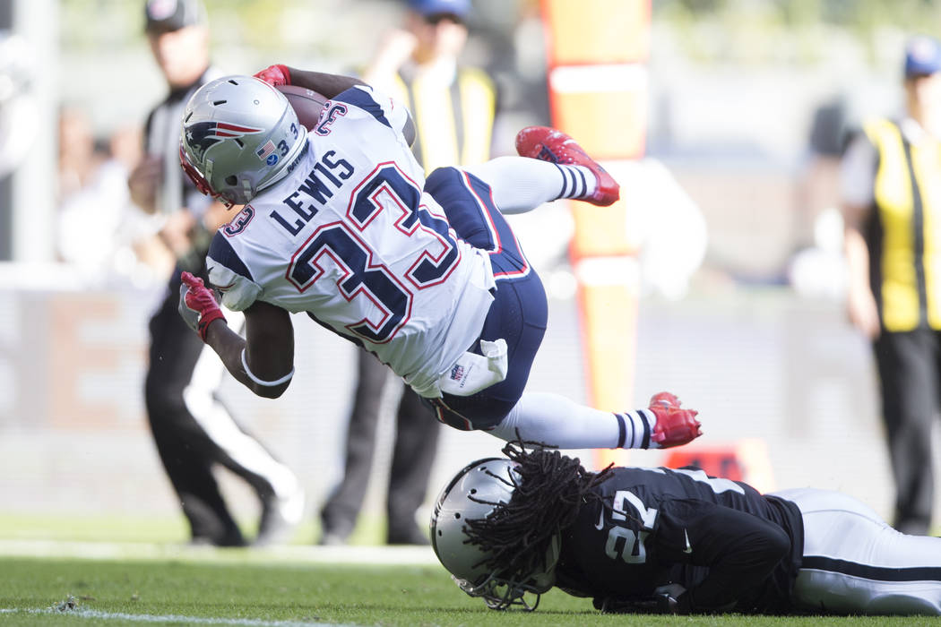 New England Patriots running back Dion Lewis (33) runs for a touchdown against Oakland Raiders free safety Reggie Nelson (27) in the NFL football game at Estadio Azteca in Mexico City, Sunday, Nov ...