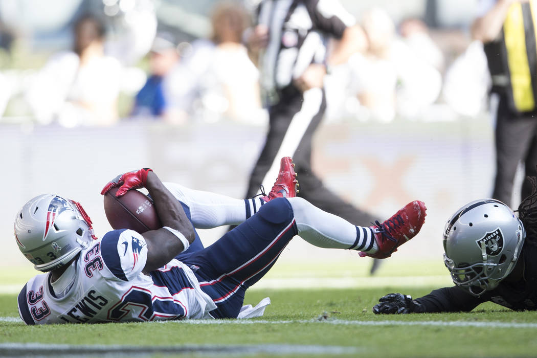 New England Patriots running back Dion Lewis (33) falls in the end zone for a touchdown against Oakland Raiders free safety Reggie Nelson (27) in the NFL football game at Estadio Azteca in Mexico ...