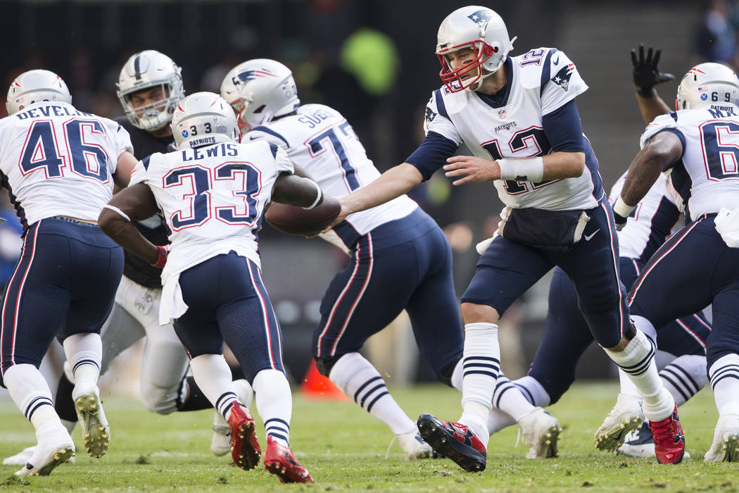 New England Patriots quarterback Tom Brady (12) hands the ball to New England Patriots running back Dion Lewis (33) in the NFL football game against the Oakland Raiders at Estadio Azteca in Mexico ...