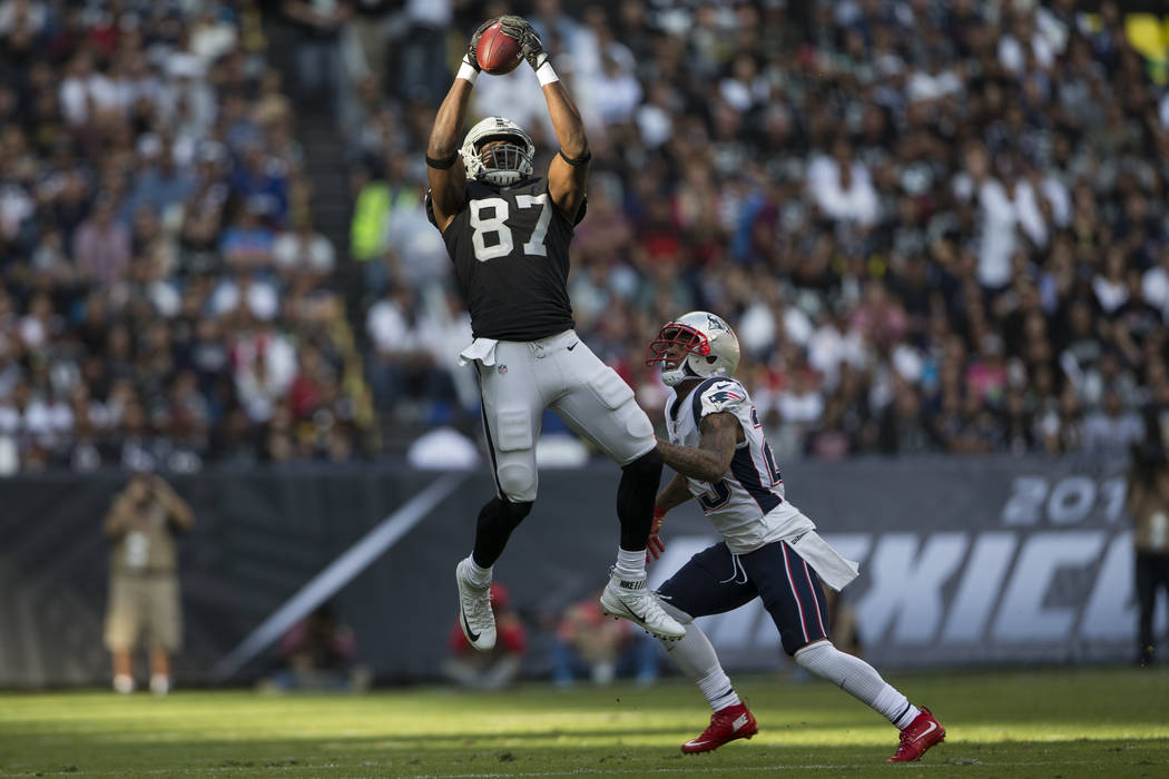 Oakland Raiders tight end Jared Cook (87) makes a catch against New England Patriots strong safety Patrick Chung (23) in the NFL football game at Estadio Azteca in Mexico City, Sunday, Nov. 19, 20 ...