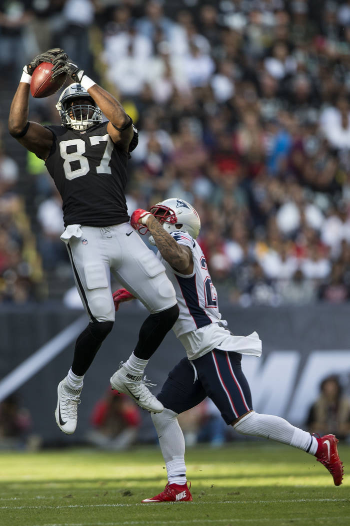 Oakland Raiders tight end Jared Cook (87) makes a catch against New England Patriots strong safety Patrick Chung (23) in the NFL football game at Estadio Azteca in Mexico City, Sunday, Nov. 19, 20 ...