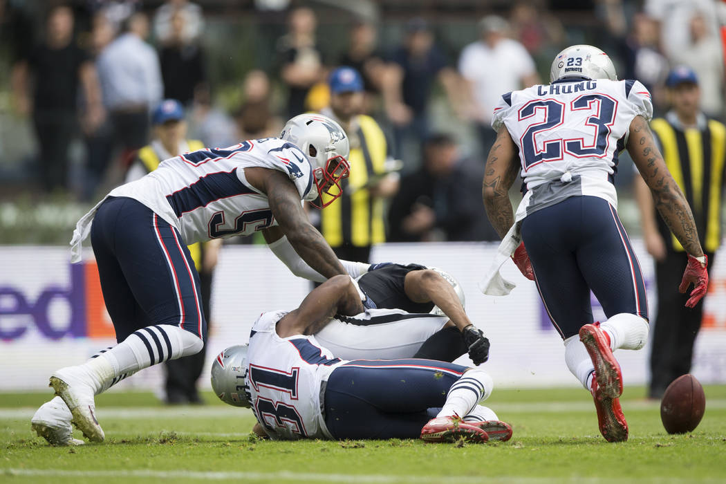 New England Patriots cornerback Jonathan Jones (31) forces a fumble against Oakland Raiders wide receiver Seth Roberts (10) forces in the NFL football game at Estadio Azteca in Mexico City, Sunday ...