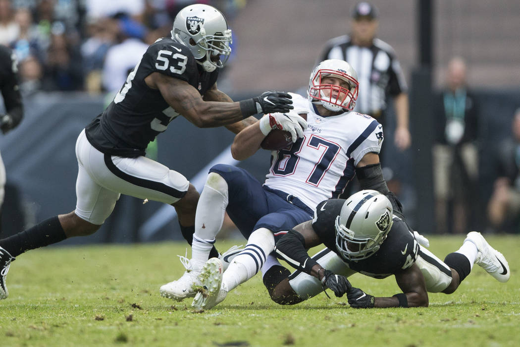New England Patriots tight end Rob Gronkowski (87) is tackled by Oakland Raiders strong safety Karl Joseph (42) after making a catch in the NFL football game at Estadio Azteca in Mexico City, Sund ...