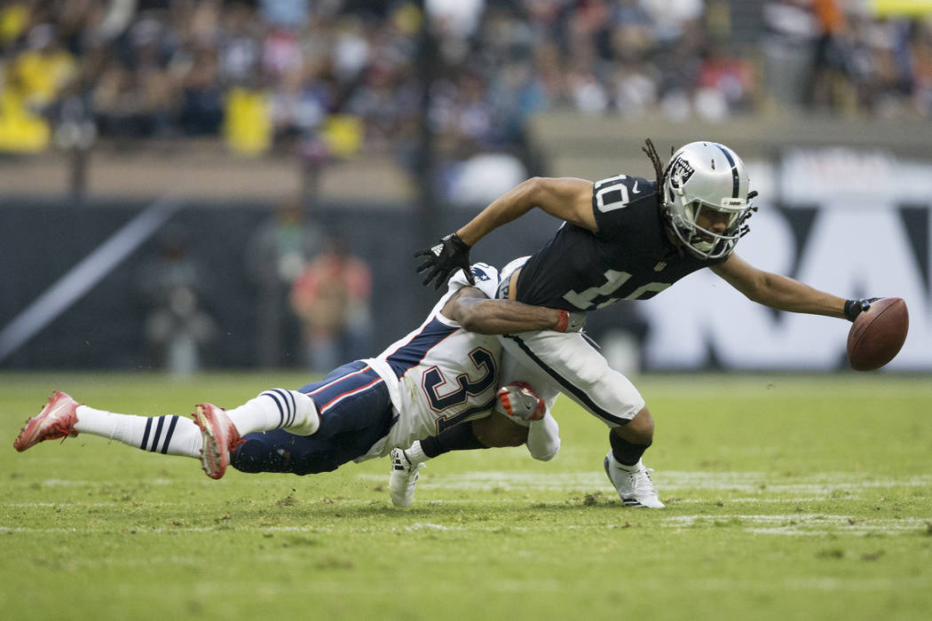 Oakland Raiders wide receiver Seth Roberts (10) fights for more yardage after a catch against New England Patriots cornerback Jonathan Jones (31) in the NFL football game at Estadio Azteca in Mexi ...