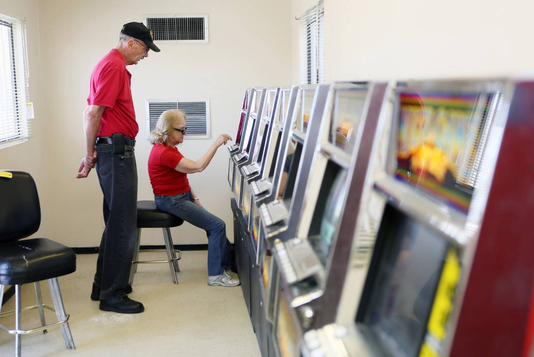 Ben Blackford, left, a United Coin Machine Co. slot technician, offers guidance to Louise Yokshus while she plays poker at a modular building at Moulin Rouge, located at 900 West Bonanza Rd., Wedn ...