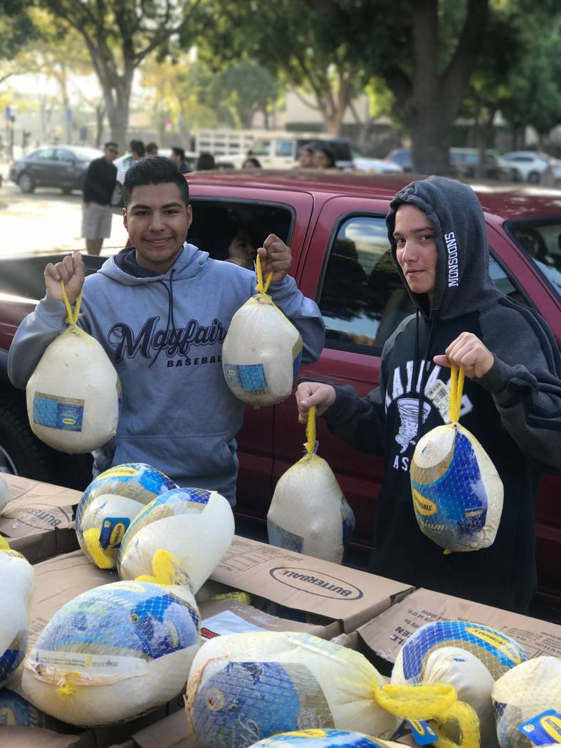 Marcus Guillen, 18, left, holds turkeys that he and members of the Leo Club, a service club affiliated with the Lion Club, collected for families on Nov. 18, 2017 in Bellflower, Calif. (Jesse Guillen)