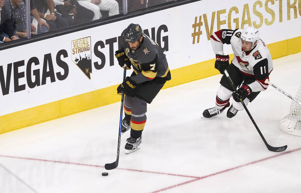 Vegas Golden Knights defenseman Jason Garrison (7) gains control of the puck as he is trailed by Arizona Coyotes left wing Brendan Perlini (11) during the first period of an NHL hockey game betwee ...