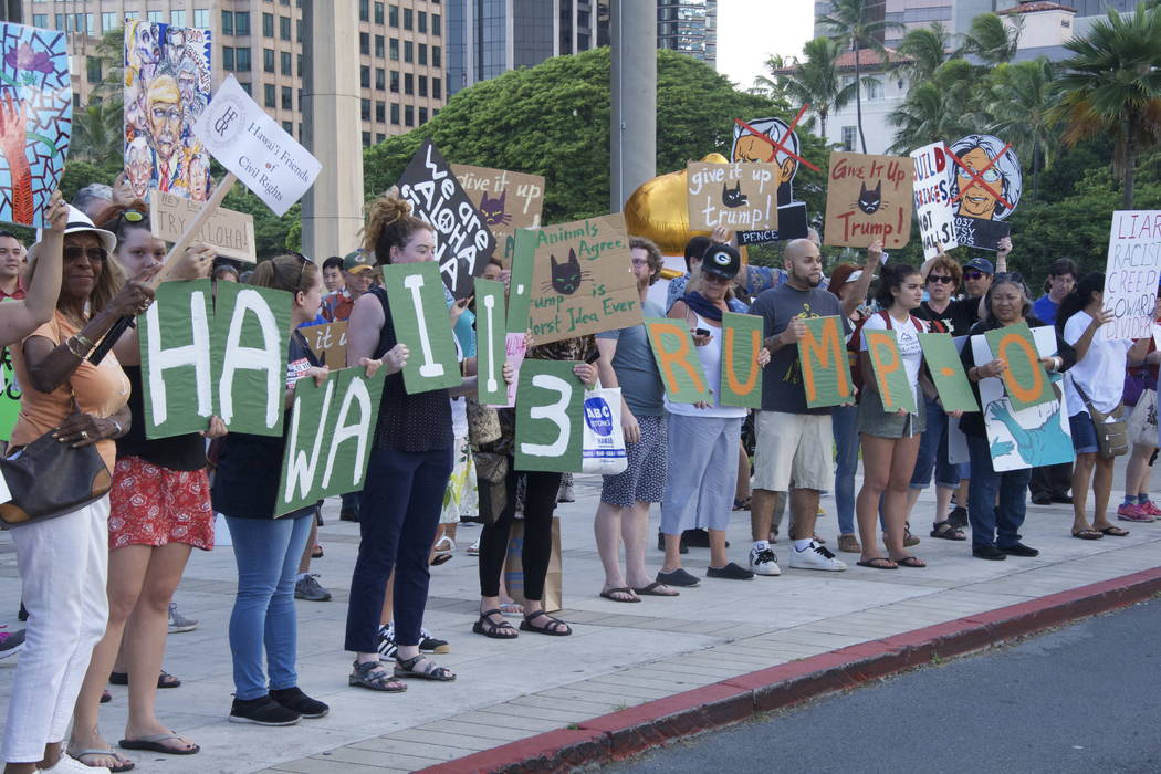 Protesters holding signs line up on Beretania Street during President Donald Trump's visit to the Capitol, Friday, Nov. 3, 2017, in Honolulu. Trump stopped in Hawaii on the eve of his first visit  ...