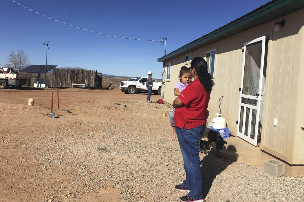 Annie Hamm holds her great-granddaughter outside her home on the Navajo Nation near Montezuma Creek, Utah. (Deenise Becenti/Navajo Tribal Utility Authority via AP)
