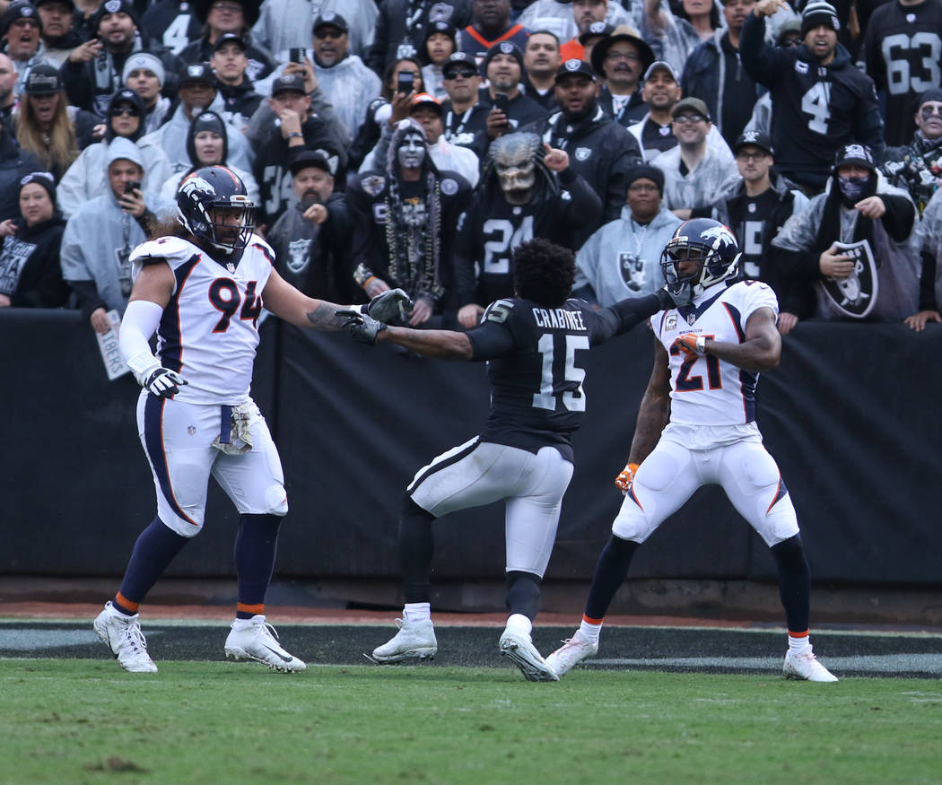 Oakland Raiders wide receiver Michael Crabtree (15) gets involved in a skirmish with Denver Broncos nose tackle Domata Peko (94) and cornerback Aqib Talib (21) during the first half of a NFL game  ...
