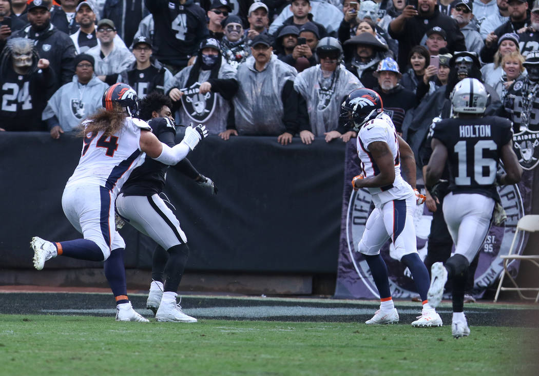 Oakland Raiders wide receiver Michael Crabtree (15) gets involved in a tussle with Denver Broncos nose tackle Domata Peko (94) as cornerback Aqib Talib (21) looks on during the first half of a NFL ...