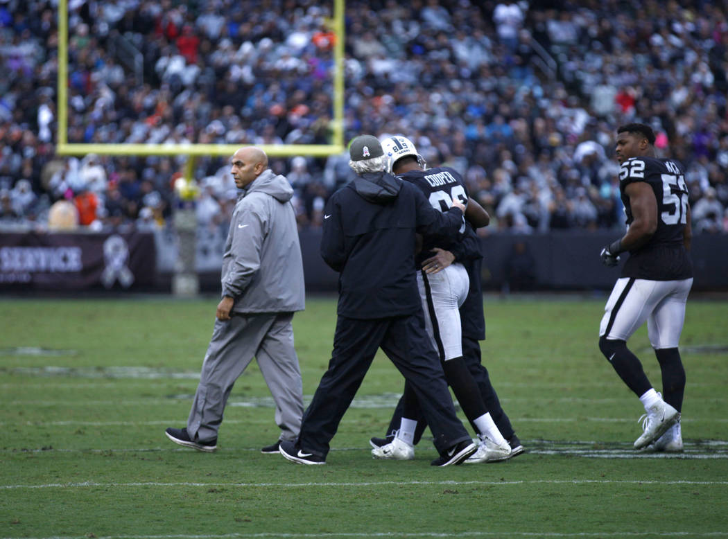 Oakland Raiders wide receiver Amari Cooper (89) is taken off the field by trainers after being knocked unconscious during the first half of a NFL game against the Denver Broncos in Oakland, Calif. ...
