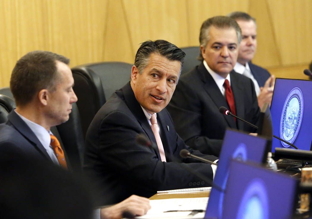 Gov. Brian Sandoval, center, speaks as Gaming Control Board Chairman, A.G. Burnett, left, and Gaming Commission Chairman, Tony Alamo, look on during the Gaming Policy Committee, which meets at the ...