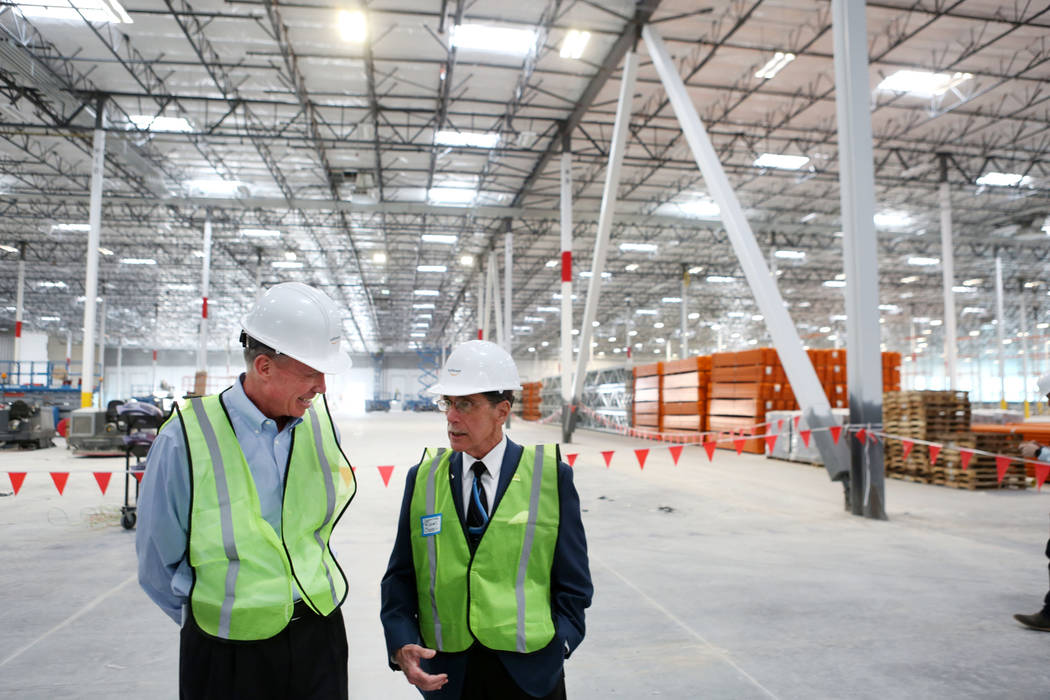 Keith Earnest, executive vice president of VanTrust Real Estate LLC, left, and North Las Vegas Councilman Richard Cherchio speak during a tour given of the newest Amazon warehouse that is under co ...