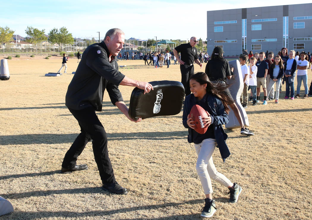 Linden King, a Raiders alumni, tries to block Lauren Phommaline, 10, during the Raiders NFL Play 60 challenges event at Josh Stevens Elementary School on Tuesday, Nov. 28, 2017, in Henderson. The  ...