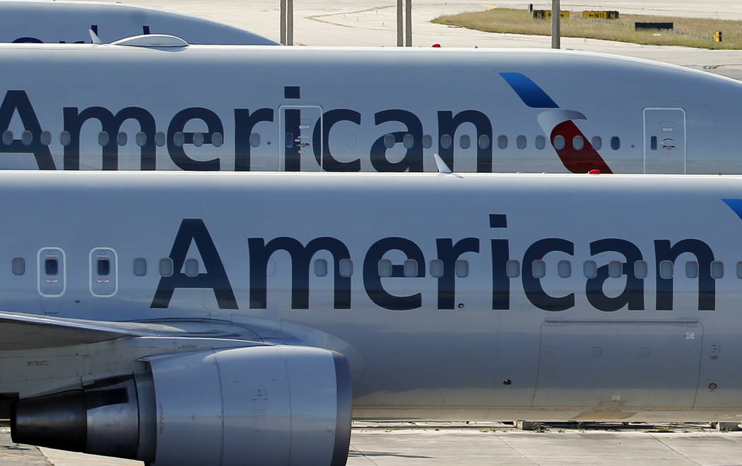 A pair of American Airlines jets are parked on the airport apron at Miami International Airport in Miami, Monday, Nov. 6, 2017. (AP Photo/Wilfredo Lee, File)