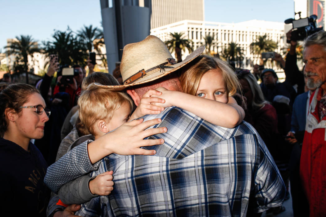 Ammon Bundy embraces his children outside the Lloyd George U.S. Courthouse in Las Vegas, after being released from custody Thursday, Nov. 30, 2017. Bundy's trial related to a 2014 Bunkerville stan ...