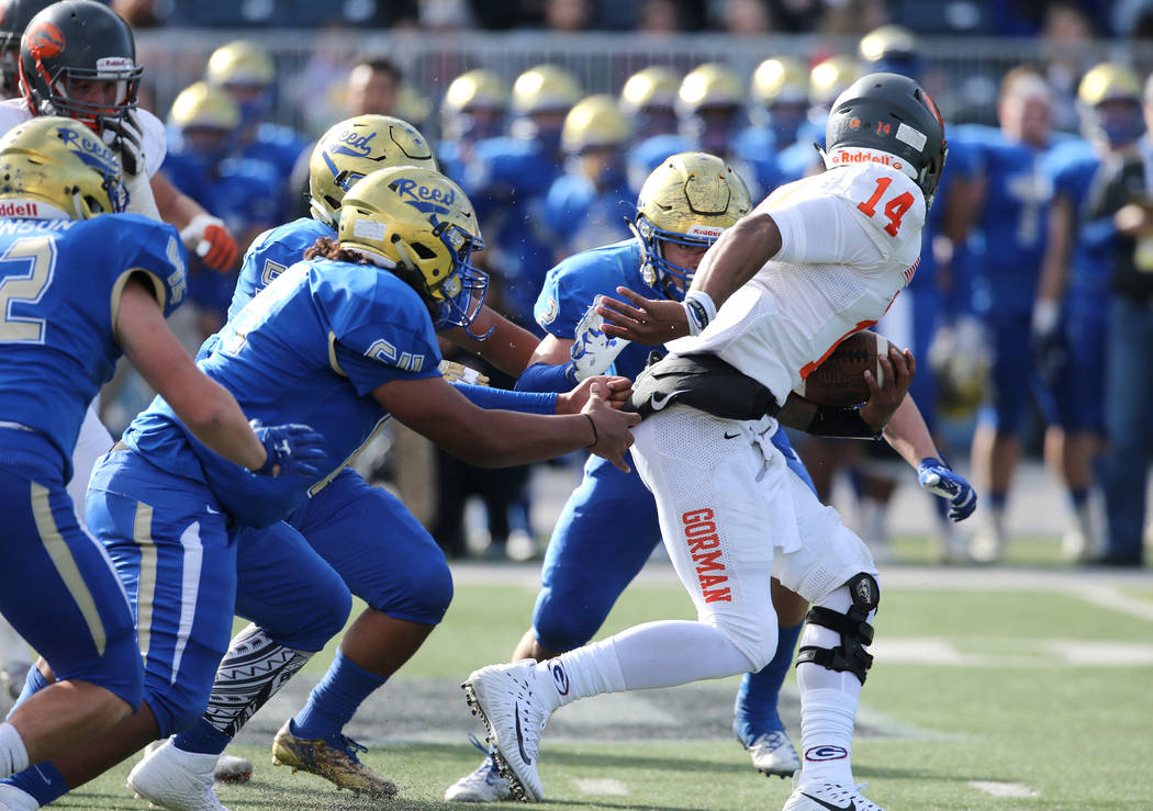 Bishop Gorman's quarterback Dorian Thompson-Robinson scrambles under pressure from Reed during the first half of the NIAA 4A state championship football game in Reno, Nev., on Saturday, Dec. 2, 20 ...