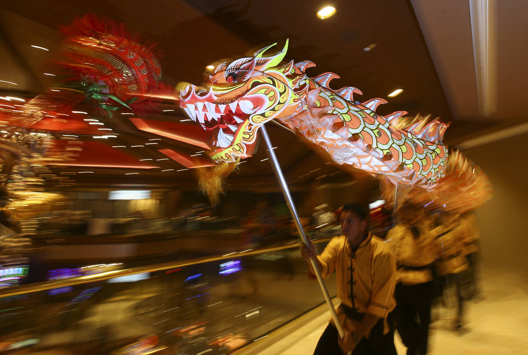 Oscar Cisneros, center, of the Lohan School of Shaolin entertains the crowd with a traditional lion and dragon dance during the 1-year anniversary of the Lucky Dragon in Las Vegas on Sunday, Dec.  ...