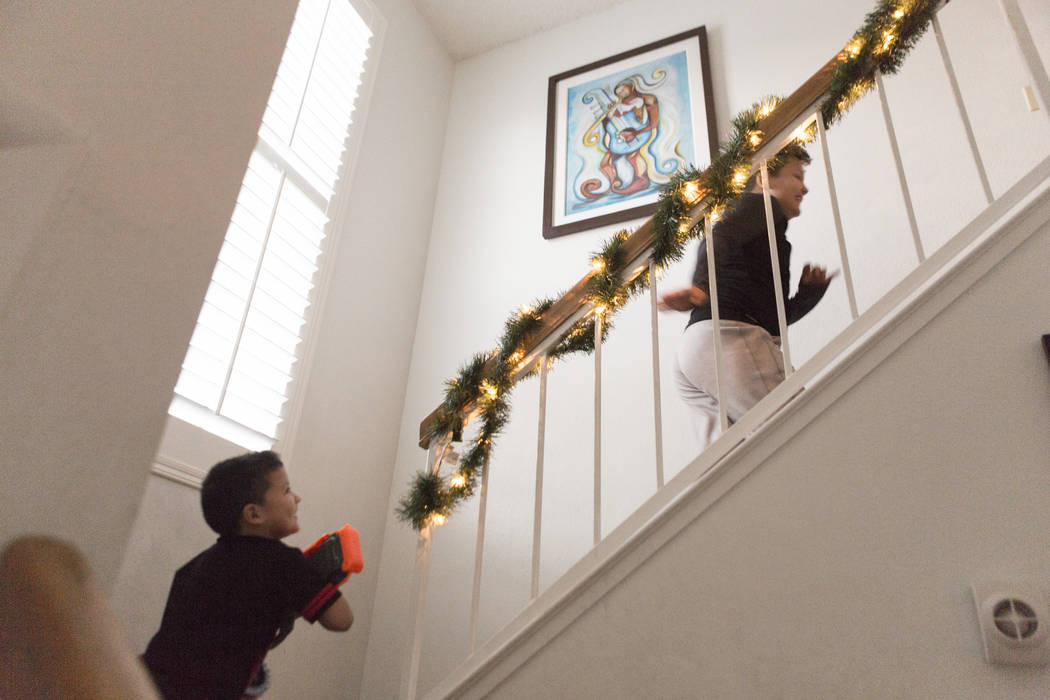 Maximus Calderon, 6, chases Eli King, 8, up the stairs with their gifts given to them by Central Church, Wednesday, Dec. 6, 2017 in Las Vegas. Elizabeth Brumley Las Vegas Review-Journal  @EliPagePhoto