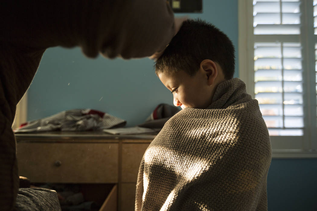 Maximus Calderon, 6, gets ready for school with the help of his dad William King in their home Friday morning, Dec. 8, 2017 while they get ready for school, in Las Vegas. Elizabeth Brumley Las Veg ...