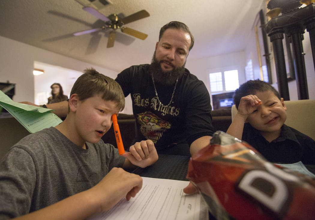 Enoch king, 9, left, William King, and Maximus Calderon, 6, works on homework in their Las Vegas home Wednesday Dec. 6, 2017. Elizabeth Brumley Las Vegas Review-Journal  @EliPagePhoto