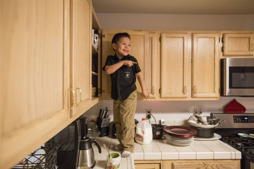 Maximus Calderon, 6, takes a break from homework to get his own cup of milk before his mom caught him and told him to get down, in their Las Vegas home Wednesday Dec. 6, 2017. Elizabeth Brumley La ...