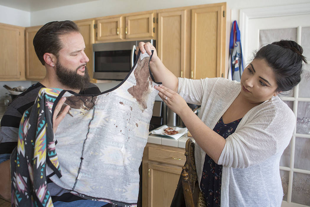 William King and Kimberly Calderon, hold shirts in their Las Vegas home Wednesday, Dec. 13, 2017, that they wore Oct. 1, 2017, during the Route 91 Harvest festival shooting where King was shot in  ...