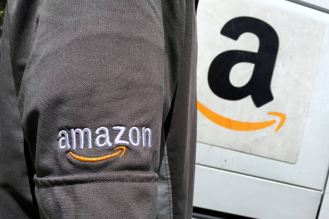 An Amazon.com Inc driver stands next to an Amazon delivery truck in Los Angeles. (REUTERS/Lucy Nicholson)
