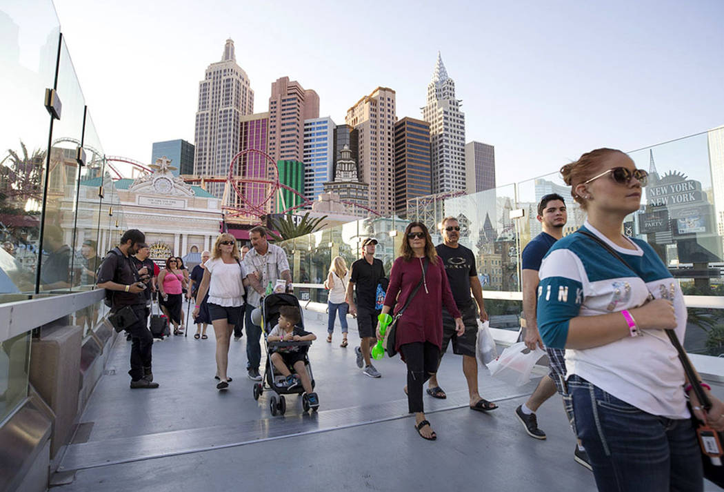 People walk over a pedestrian bridge linking New York-New York and MGM Grand near the intersection of Las Vegas Boulevard and Tropicana Avenue in Las Vegas, Thursday, Oct. 12, 2017. Richard Brian ...