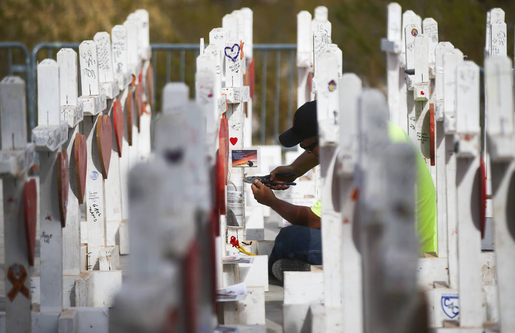 Volunteer Steve Round works on removing items from the crosses that were moved from a makeshift memorial at the &quot;Welcome to Fabulous Las Vegas Sign&quot; to the Clark County Museum in ...