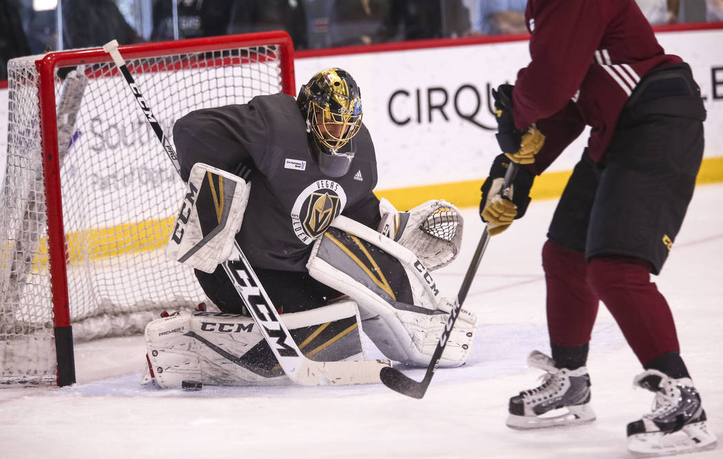 Vegas Golden Knights goalie Marc-Andre Fleury, left, deflects the puck in a drill during the NHL team's practice at the City National Arena in Las Vegas, Wednesday, Dec. 6, 2017. Richard Brian Las ...