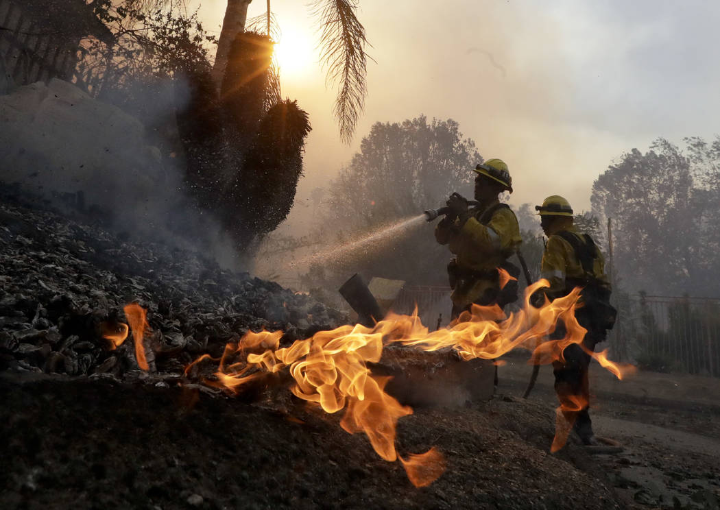 Los Angeles County firefighters battle a wildfire in the Lake View Terrace area of Los Angeles, Tuesday, Dec. 5, 2017. (AP Photo/Chris Carlson)