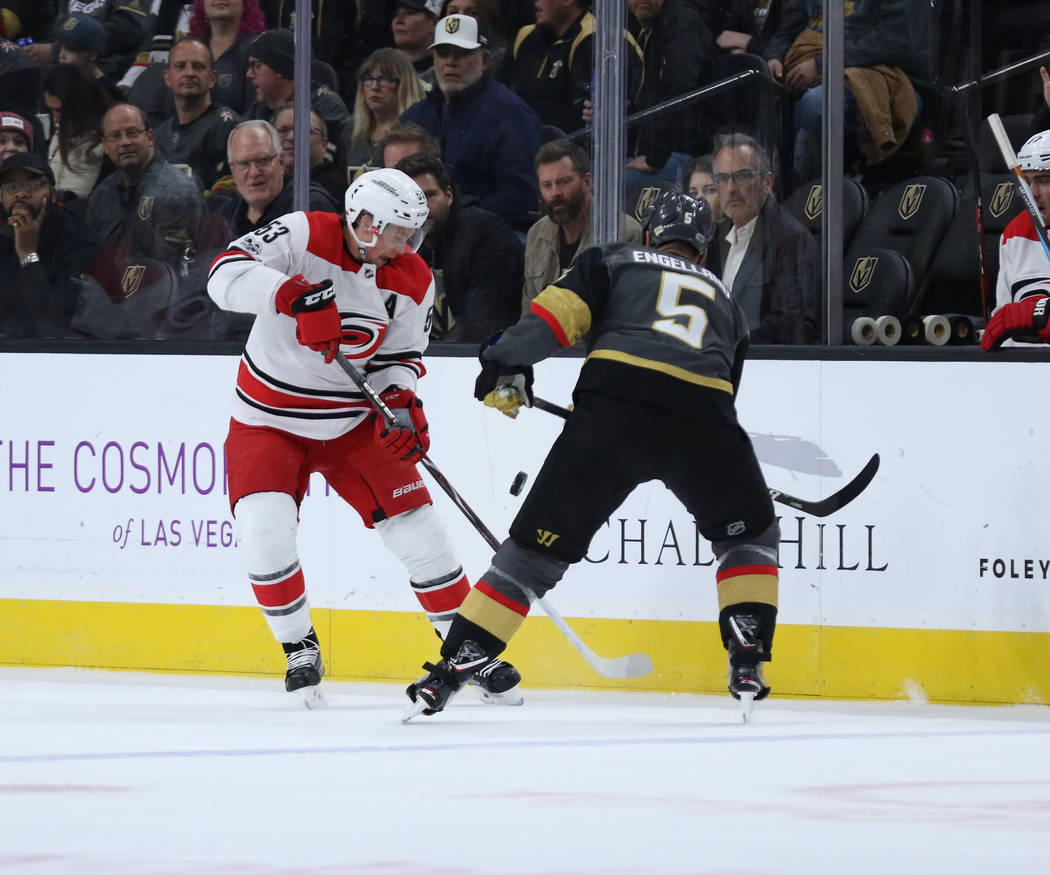 Carolina Hurricanes left wing Jeff Skinner (53) and Vegas Golden Knights defenseman Deryk Engelland (5) fight for possession during the first period of a NHL game in Las Vegas, Tuesday, Dec. 12, 2 ...