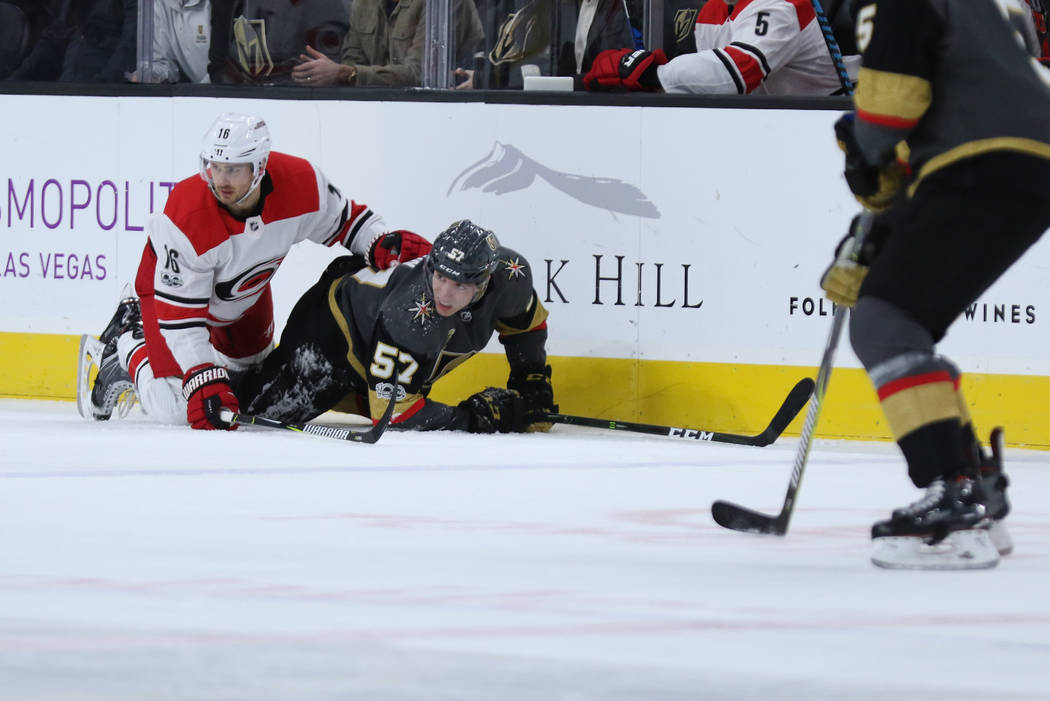 Vegas Golden Knights left wing David Perron (57) and Carolina Hurricanes center Marcus Kruger (16) fall on the ice during the first period of a NHL game in Las Vegas, Tuesday, Dec. 12, 2017. Heidi ...