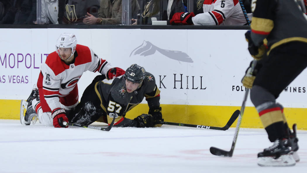 Vegas Golden Knights left wing David Perron (57) and Carolina Hurricanes center Marcus Kruger (16) fall on the ice during the first period of a NHL game in Las Vegas, Tuesday, Dec. 12, 2017. Heidi ...