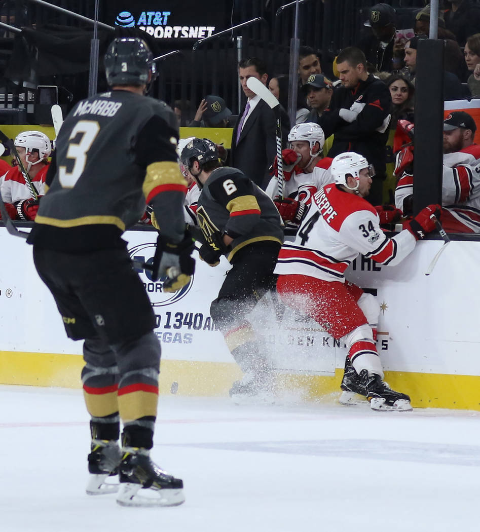 Carolina Hurricanes left wing Phillip Di Giuseppe (34) and Vegas Golden Knights defenseman Colin Miller (6) fight for the puck against the wall during the first period of a NHL game in Las Vegas,  ...
