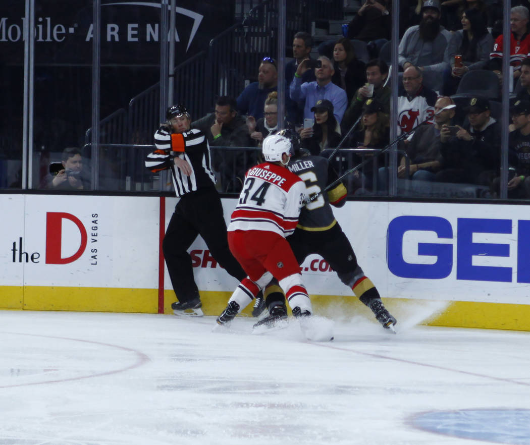 Carolina Hurricanes left wing Phillip Di Giuseppe (34) and Vegas Golden Knights defenseman Colin Miller (6) push each other against the glass during the first period of a NHL game in Las Vegas, Tu ...